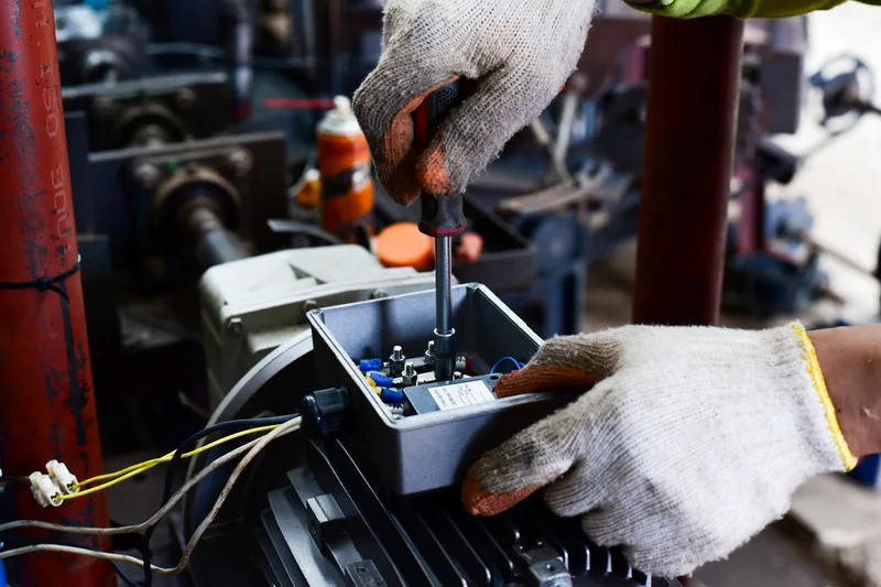 An electrician wiring a motor junction box