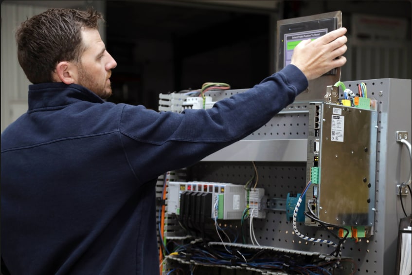A Shorite Controls technician working at an operator panel